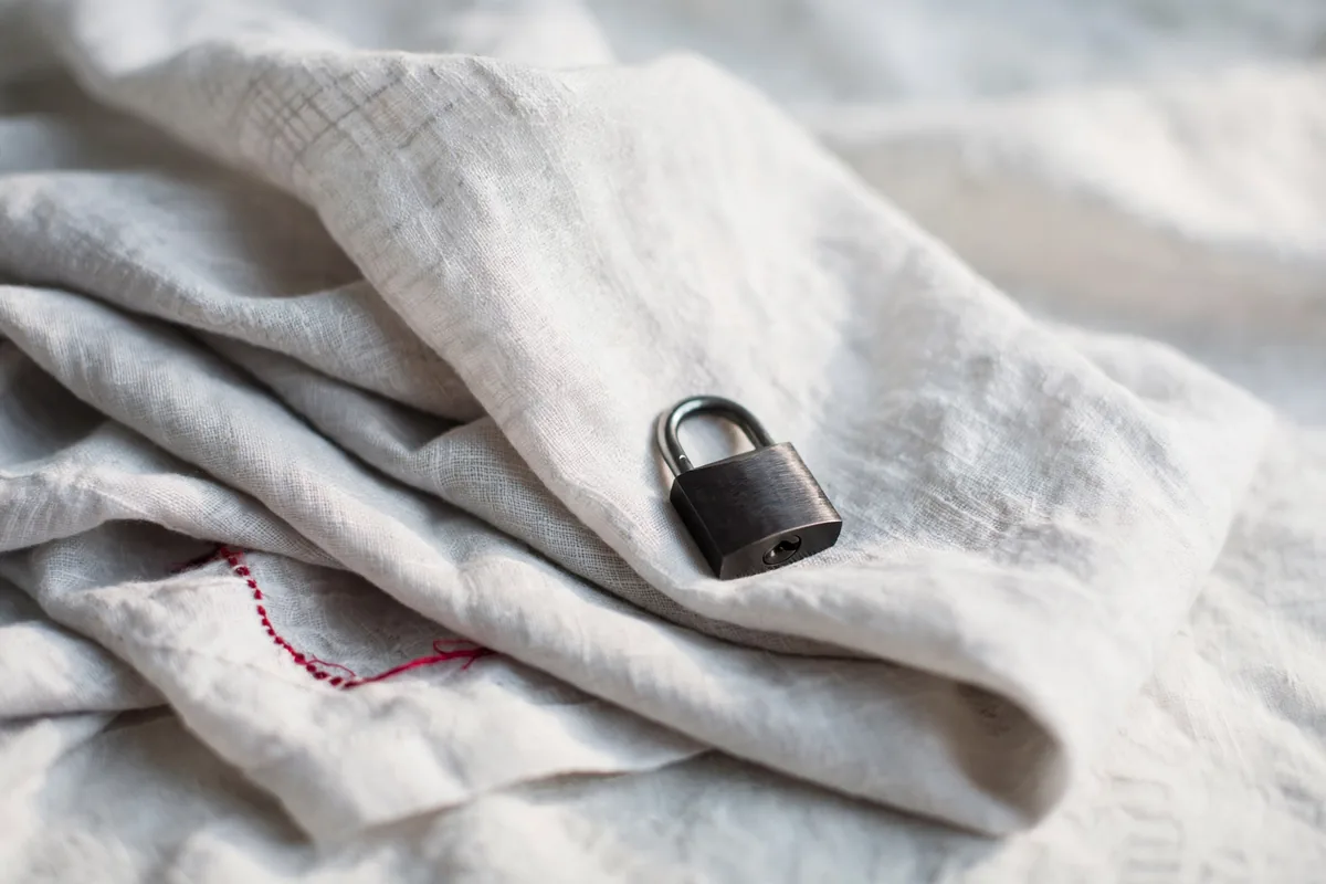 A small padlock resting on folded fabric